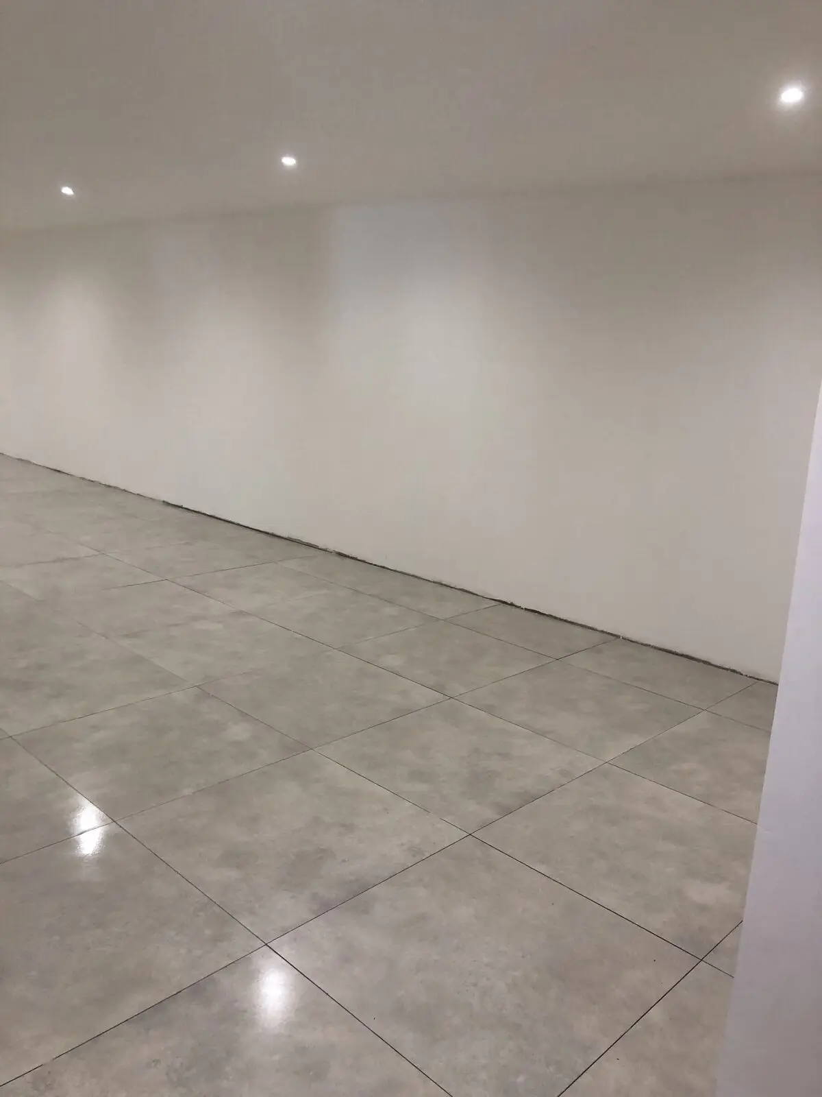 Murs refaits, peints en blanc, sol carrelé et spots encastrés
