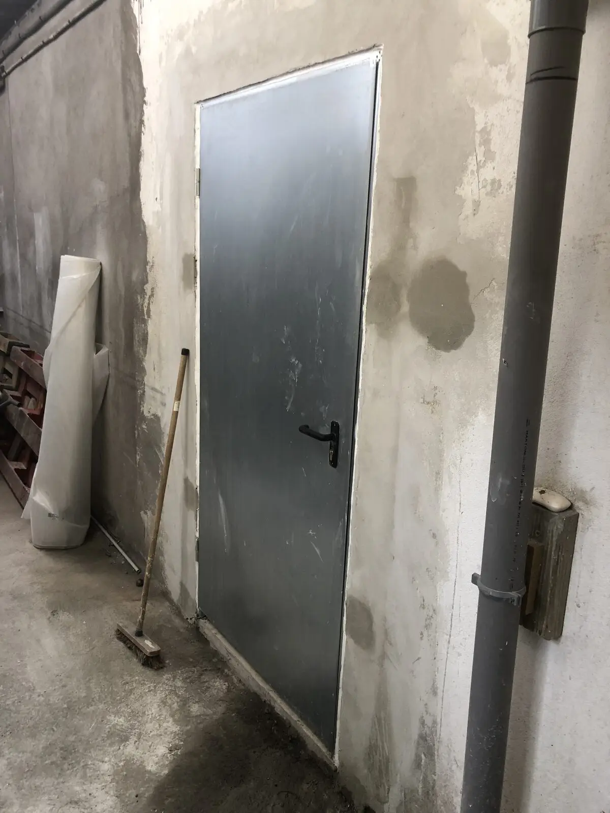 Ancienne porte métallique et mur extérieur dégradé