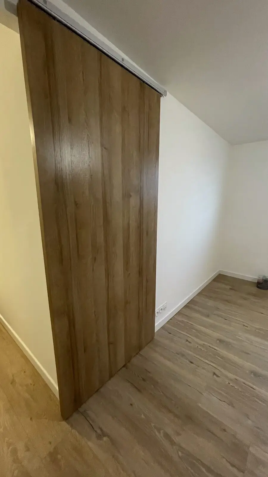 Porte coulissante en bois séparant deux espaces