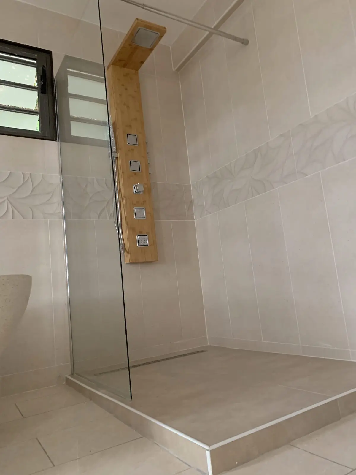 Douche à l’italienne carrelée avec paroi vitrée et colonne de douche