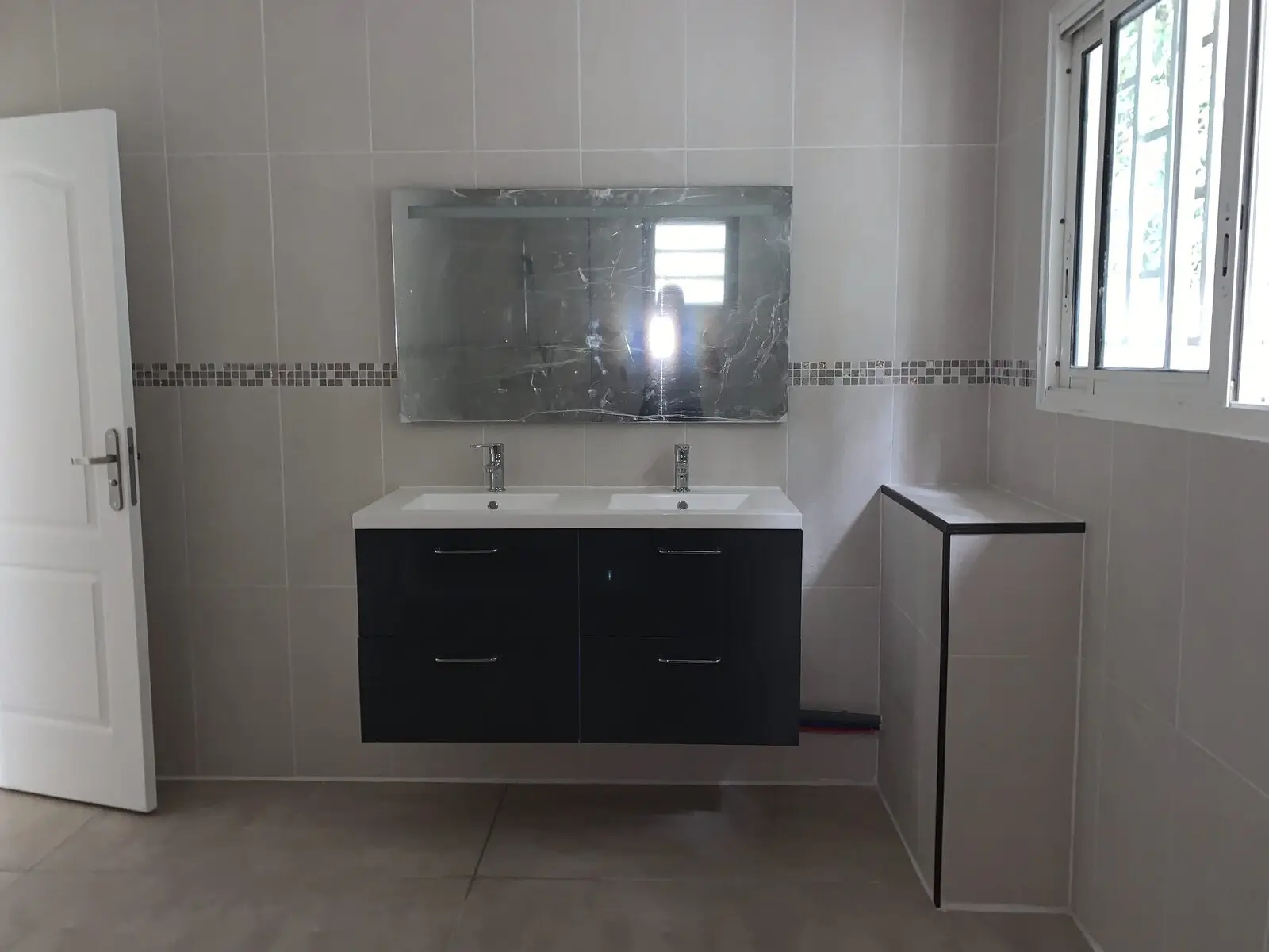 Salle d’eau refaite avec meuble double vasque suspendu et grand miroir
