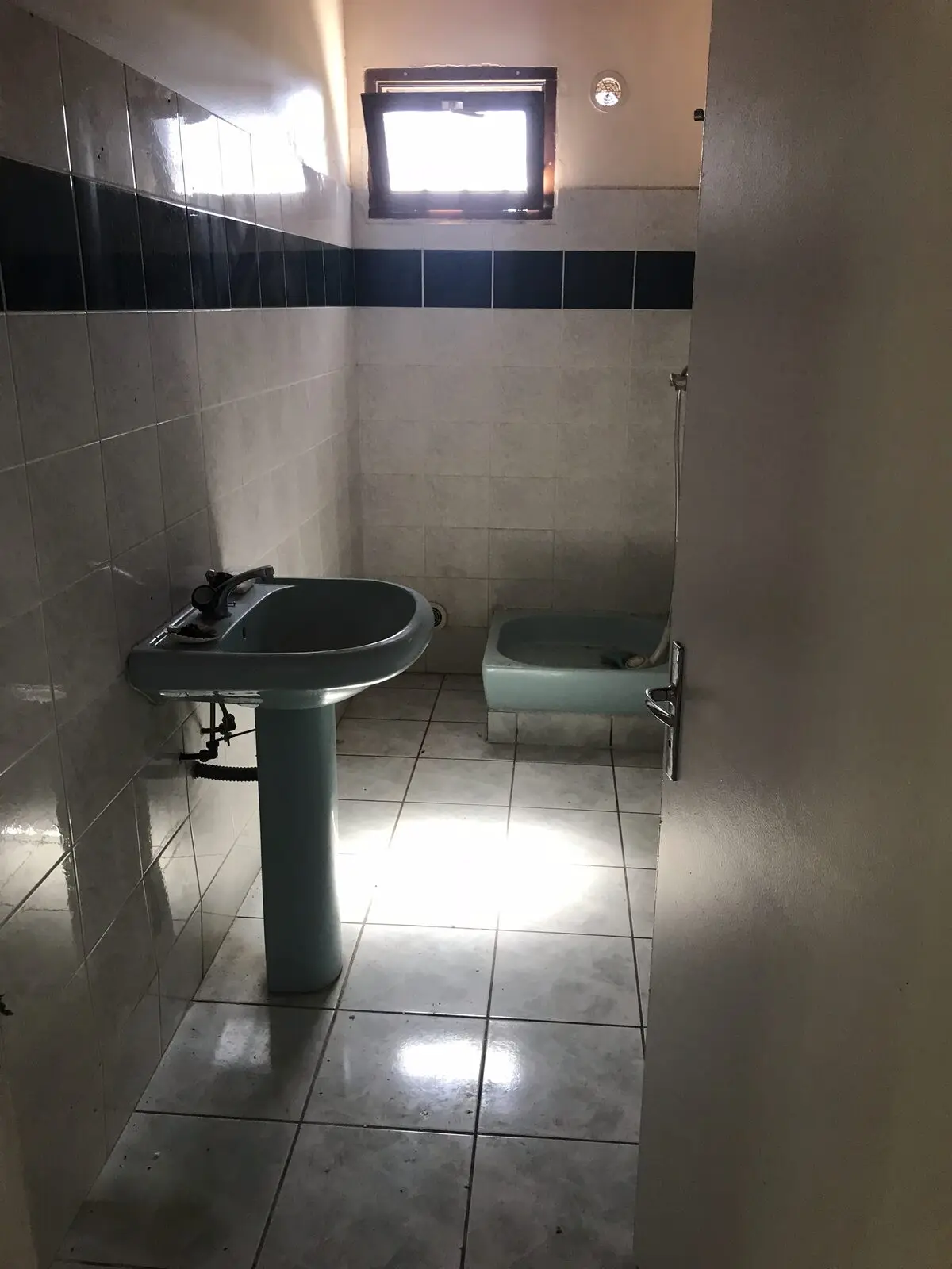 Ancien sanitaire avec lavabo sur colonne et faïence à bandeau noir