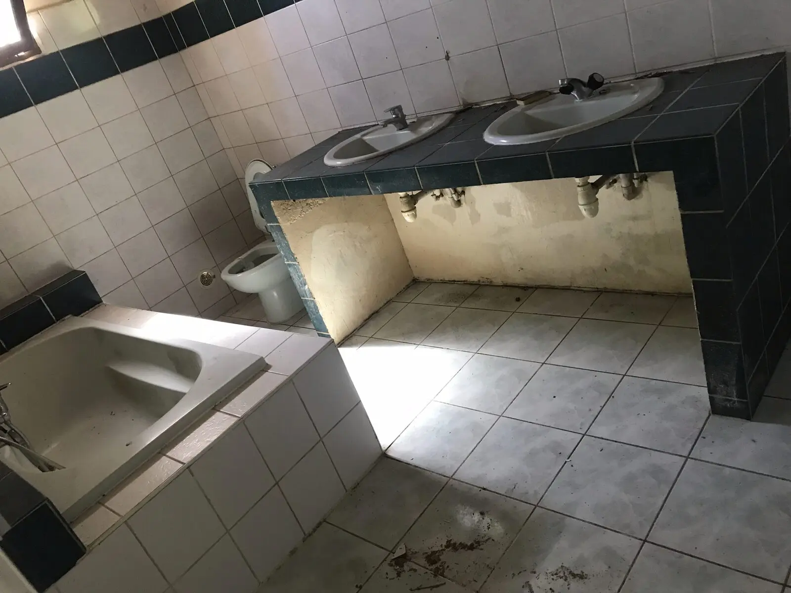 Salle de bain d’origine à déposer : faïence vert foncé, plan vasque maçonné, baignoire encastrée
