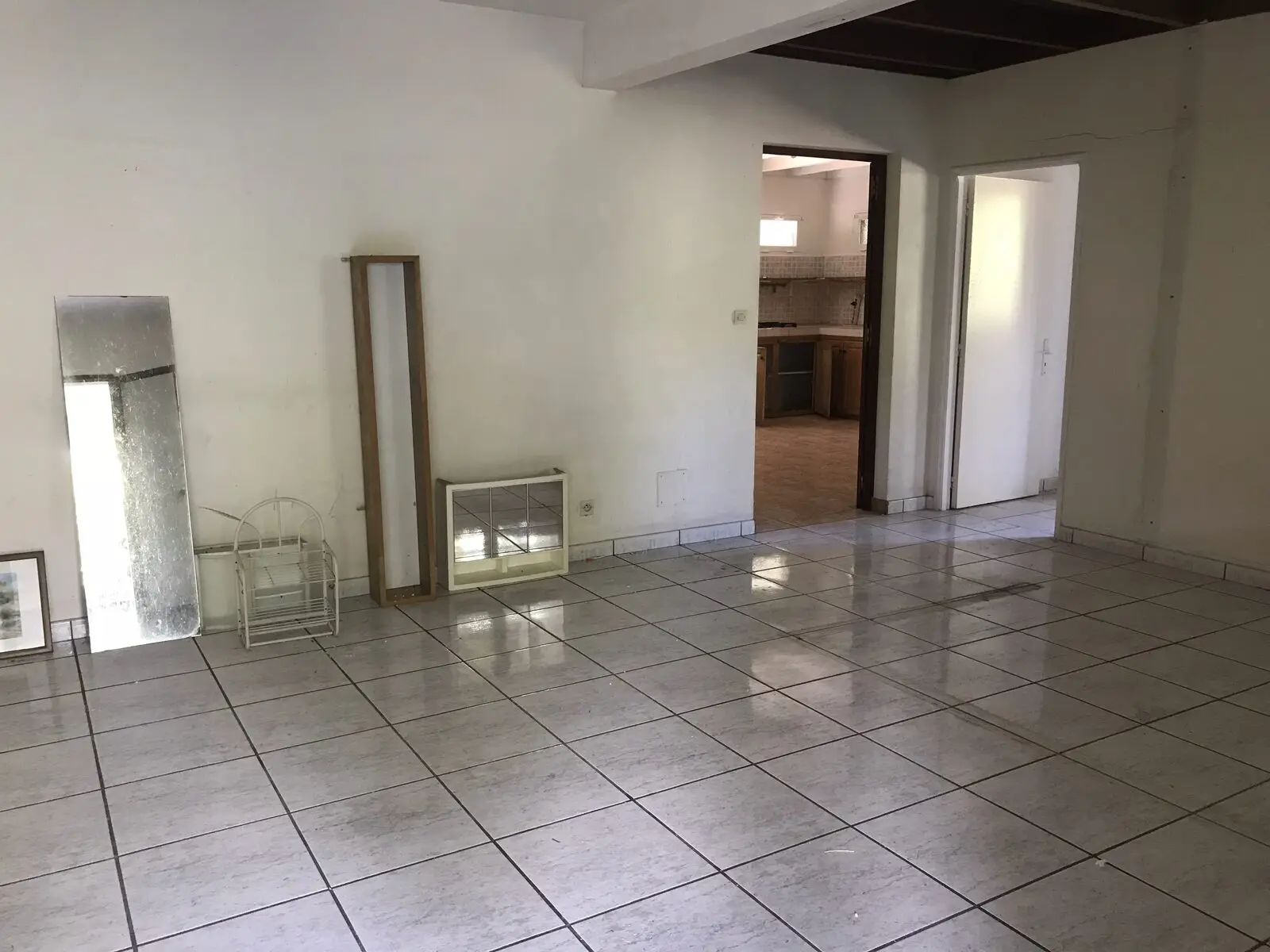 Séjour d'une maison à Sainte-Marie avant travaux : carrelage blanc d'origine, cloisonnement fermé
